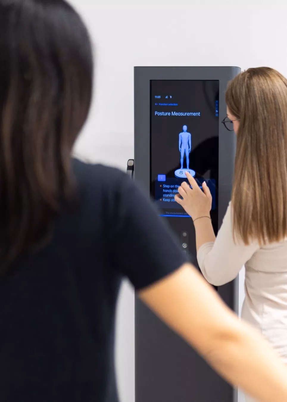 Frau tippt auf den Touchscreen eines Visbody-Scanspiegels